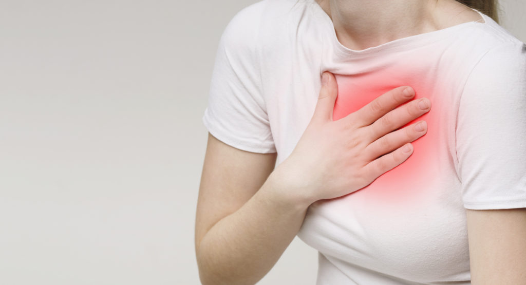 Woman suffering from acid reflux or heartburn, symptomatic indigestion or gastritis disease, panorama